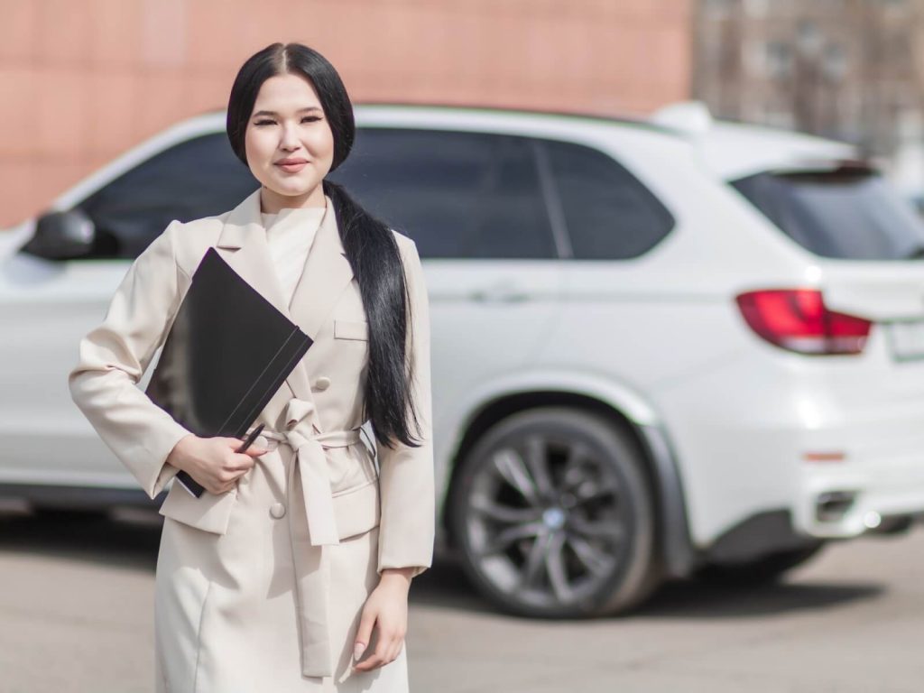 Columbus auto insurance agent stands in front of car