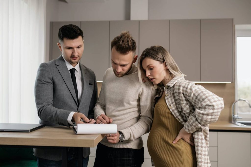 realtor reviews paperwork with couple